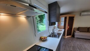 Eine moderne Küche mit Einbauofen, Spüle und Fenster mit Blick auf einen Garten.