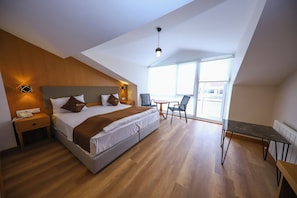 A modern bedroom with a large bed, bedside tables, a desk, and a chair. - Ruby Royal Hotel (Istanbul)