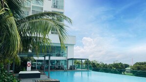 A modern hotel with a swimming pool, outdoor seating, and a view of the surrounding greenery. - Paragon Suite By Antlerzone (Johor Bahru)