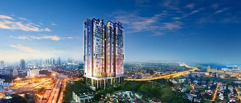 A high-rise building with multiple floors, surrounded by a cityscape with roads and other buildings.
