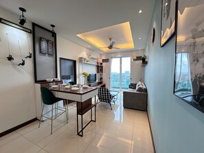 Un salon moderne comprenant un coin repas, un ventilateur de plafond et une grande fenêtre donnant sur la ville.