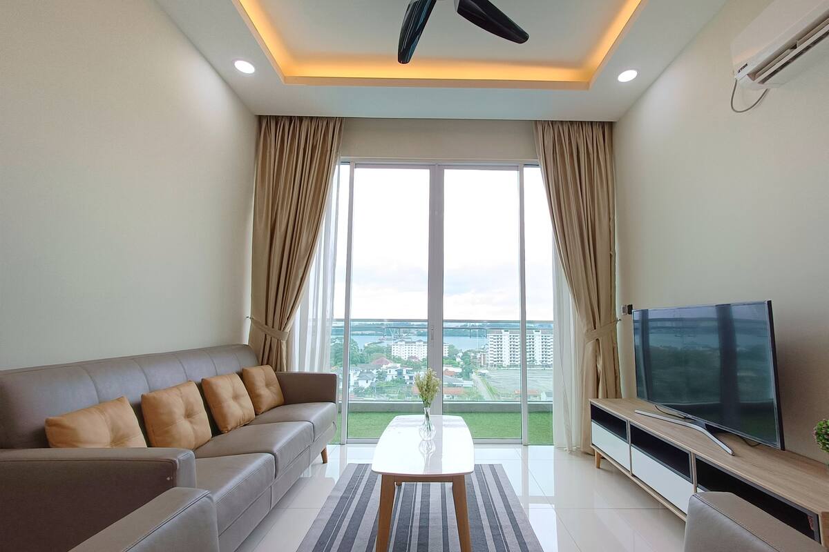 A modern living room with a sofa, a coffee table, and a television.