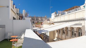 A rooftop terrace with white canopies, a small seating area with chairs, and a view of historic buildings in the background. - Lukanda Hospec Olehousing (Seville)