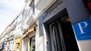 A street view with a building labeled 'luxanda' and a blue 'P' parking sign. - Lukanda Hospec Olehousing (Seville)
