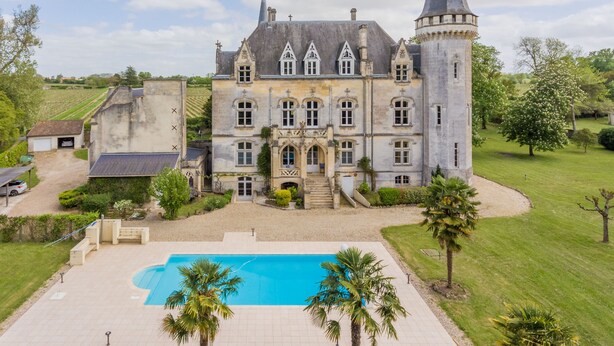 A large, historic building with a prominent tower, a swimming pool, and well-maintained gardens. - Fairytale Chateau with pool surrounded by vineyard and parc (Blaye)