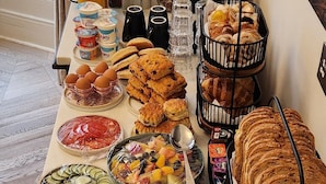 A buffet table with various food items including bread, pastries, and condiments. - Boutique 50 (Glasgow)
