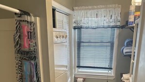 A compact bathroom with a washing machine, toilet, and sink.