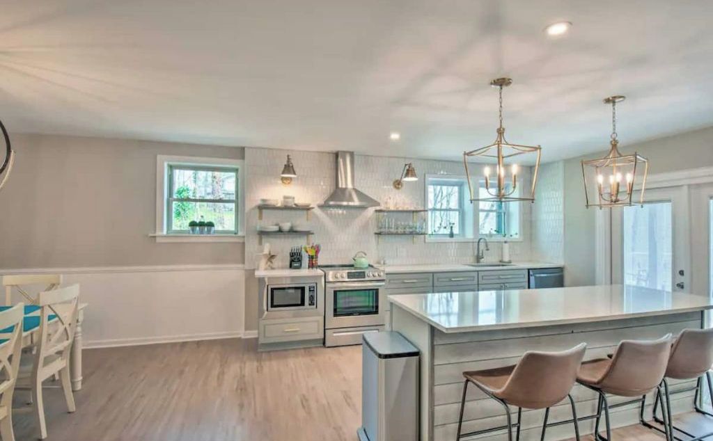 A modern kitchen with a central island, built-in appliances, and pendant lighting.