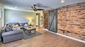 A living room with a sofa, coffee table, and a wooden accent wall. - Hidden Lake Sanctuary  (West Union)