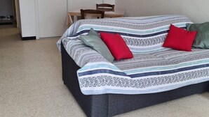 A bedroom with a bed, a chair, a table, and a door. - Charming accommodation on the port of Mèze (Mèze)