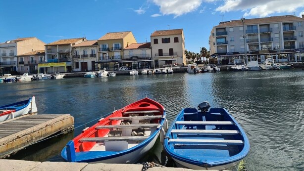 A marina with boats docked, a waterfront building with balconies, and a clear sky. - Charming accommodation on the port of Mèze (Mèze)