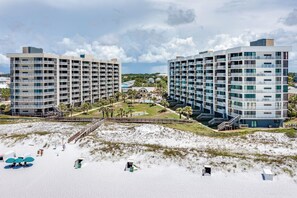 A modern hotel with multiple floors, a beach view, and a pool area.