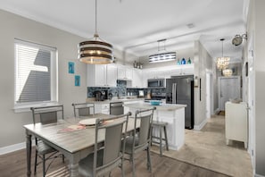 A modern kitchen with white cabinets, a central island, and stainless steel appliances.