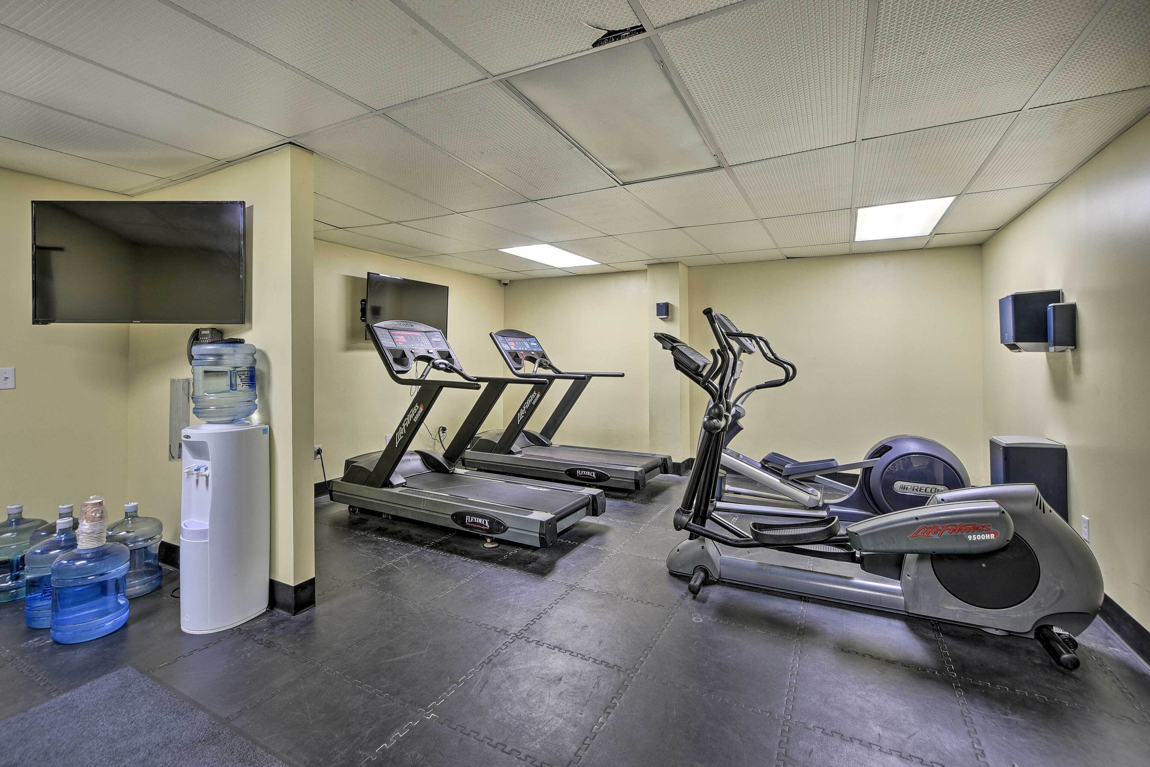 Ein Fitnessraum mit Laufbändern, einem Ergometer und Wasserspendern.