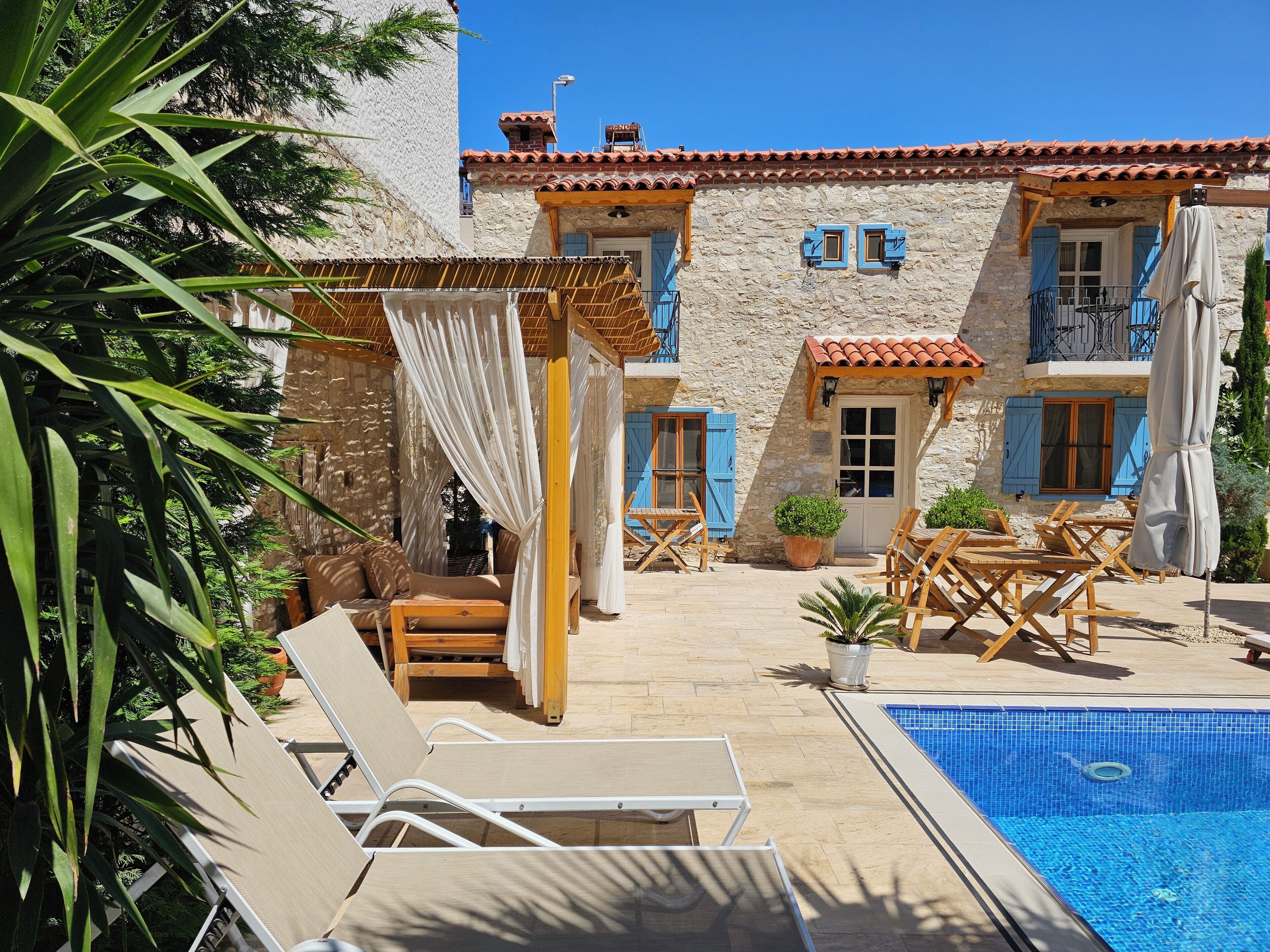 Una piscina al aire libre de temporada, sillones reclinables de piscina