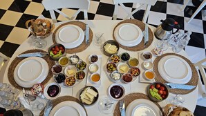 Una mesa de comedor dispuesta con platos, cubiertos y diversos alimentos.