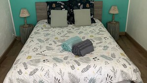 A bed with a floral-patterned bedspread, two pillows, and two bedside lamps.