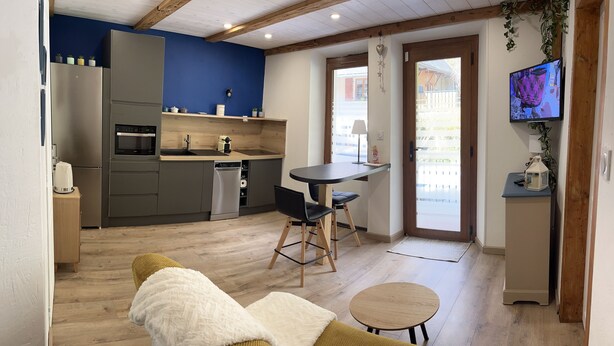 A compact living space with a kitchenette, a dining area, and a seating area.