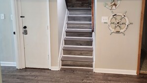 A staircase with a sign above reading "COME IN AND Stay awhile". - Cozy property, a short walk to a lake front beach. (Locust Grove)