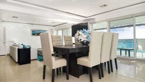 Un comedor moderno con una mesa de madera oscura, sillas tapizadas en color beige y un jarrón decorativo.