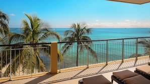 Ein Balkon mit Blick auf das Meer und Palmen.