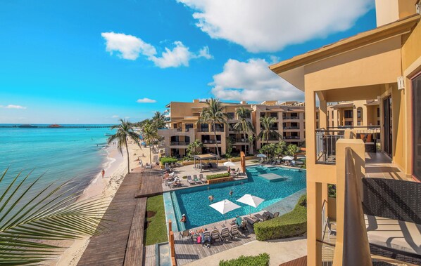 A resort with a pool, beach, and ocean view.