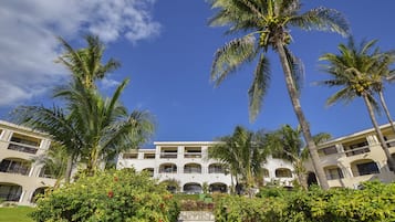 A hotel with a central courtyard, surrounded by palm trees and lush greenery.