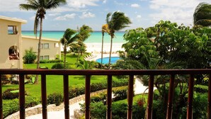A resort with a pool, palm trees, and a beach view.