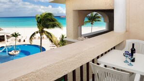 Un balcón con vista a la playa y a una piscina.