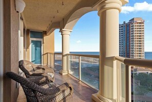 Enjoy the breathtaking view from this balcony with a clear view of the surrounding landscape, featuring a high-rise building and a body of water.