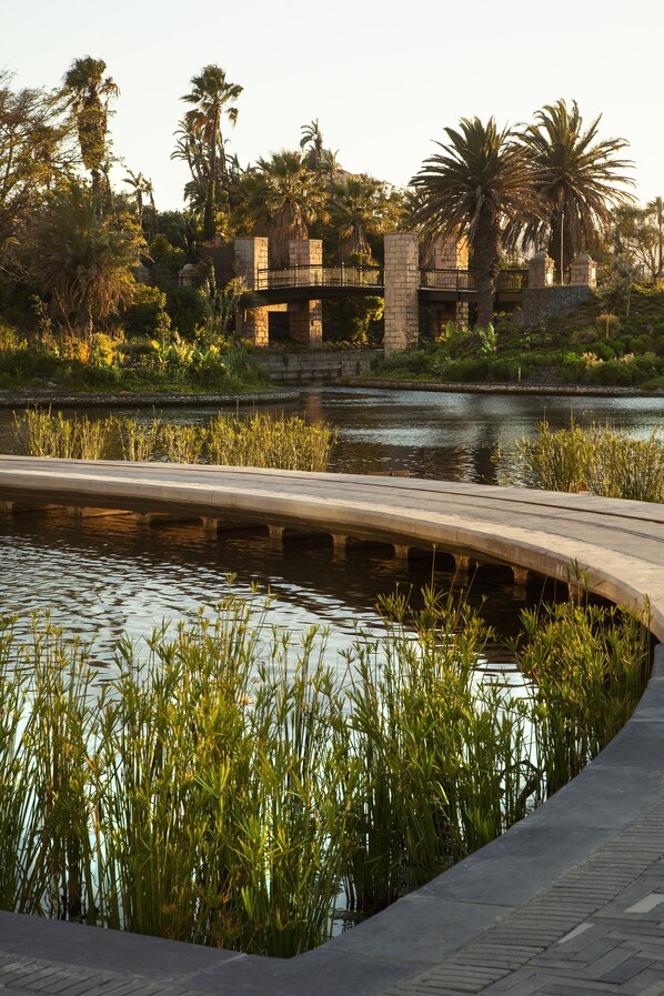 A landscaped area with a curved pathway, water feature, and stone structures.