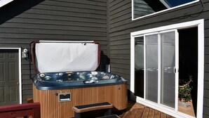Ein Whirlpool mit Holzverkleidung, einer Sitzbank und einer Schiebetür zur Rechten.