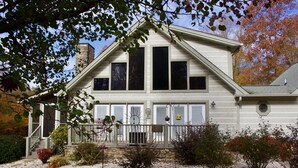 A two-story house with a stone chimney, large windows, and a front porch with a railing. - Come to "LOG OUT" and have fun! (Pinnacle)