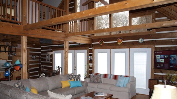 A spacious living room with two sofas, a wooden ceiling, and a TV mounted on the wall. - Come to "LOG OUT" and have fun! (Pinnacle)