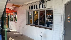 A restaurant named 'Chilte' with a 'To-Go' sign, a menu board listing items like bar snacks, house popcorn, and green chili burger, and a 'Staff Only' sign on the door. - Egyptian Motor Hotel, Bw Signature Collection (Phoenix)