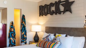 A hotel room with a bed, pillows, a nightstand, a lamp, and a wall with the word "ROCK" and a star. - Egyptian Motor Hotel, Bw Signature Collection (Phoenix)