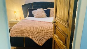 A bedroom with a bed, a nightstand, a lamp, and a wooden wardrobe. - Studio for 4 people (Les Arcs)