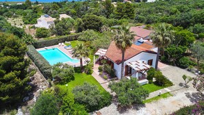 Propiedad residencial con piscina, rodeada de exuberante vegetación y vistas al mar.