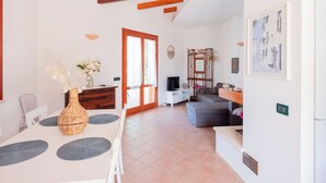Amplia sala de estar con mesa de comedor, sofá y televisor.
