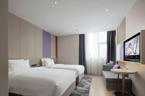 A hotel room with two beds, a TV, a small table, and a sofa. - Lavande Hotel (Zhuhai Qinglv North Road Tangjiawan Beach) (Zhuhai)