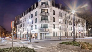 A modern hotel with a prominent "Radisson" sign, multiple balconies, and a well-lit facade. - Radisson Hotel Liege City Centre (Liege)