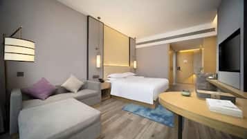 Una habitación de hotel moderna con una cama, un sofá, un escritorio y una televisión.