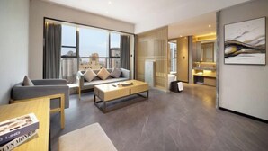 A modern living room with a sofa, coffee table, and a large window with curtains. - Mandao Hotel (Nanbu County)