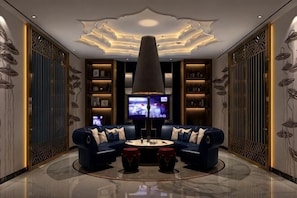 Un salon moderne avec un ensemble de canapés, un téléviseur et un plafond décoratif.