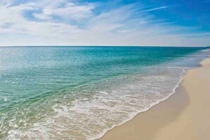 A beach with clear turquoise water and a sandy shore.