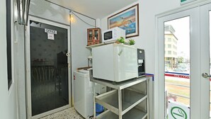 A small office with a refrigerator, microwave, and a smoking area sign. - OYO Home 90427 Mm Homestay (Segamat)
