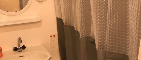 A bathroom with a white sink, a mirror, and a shower curtain.