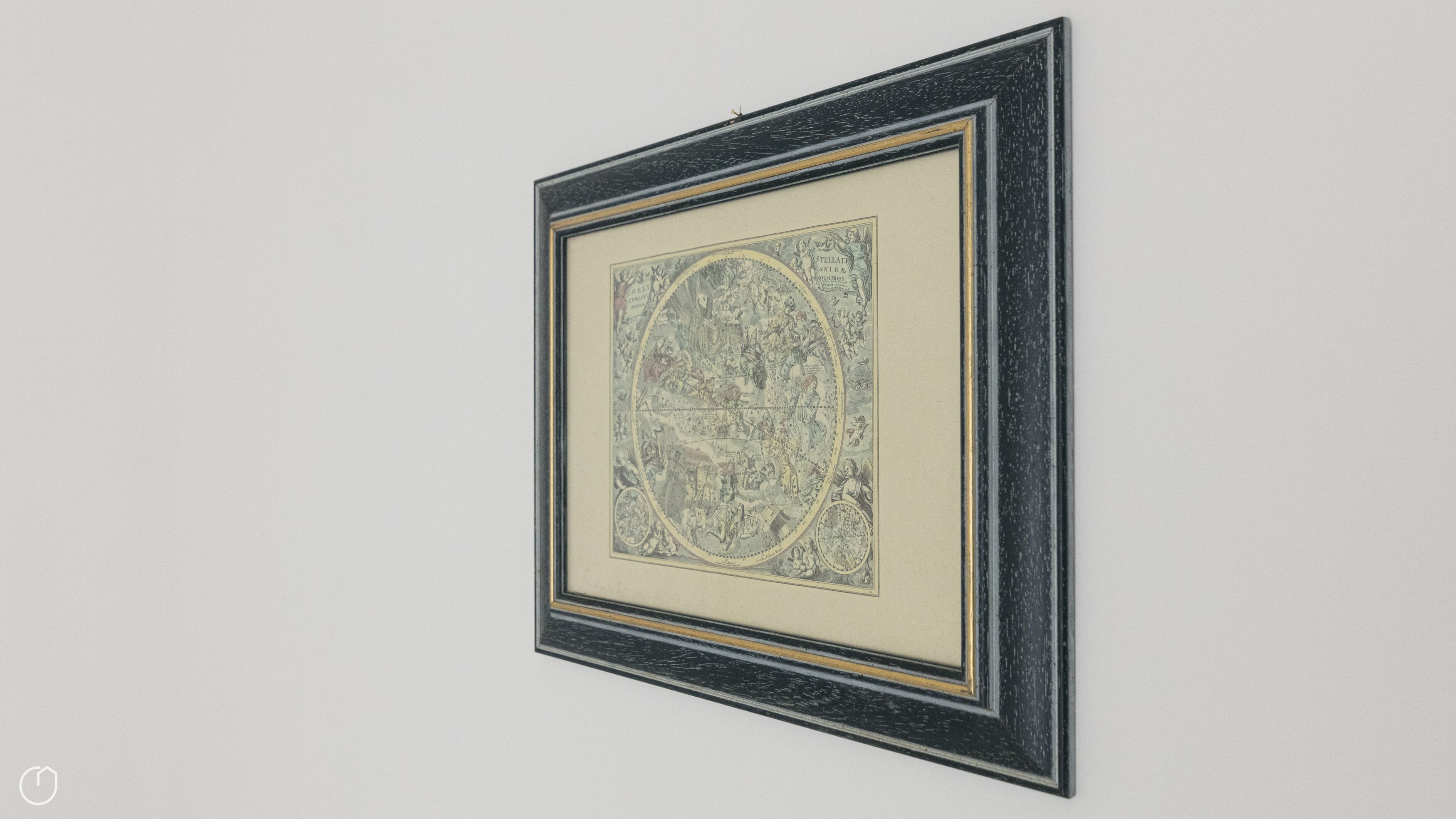 A framed artwork with a circular central design, surrounded by a black frame with a gold trim.