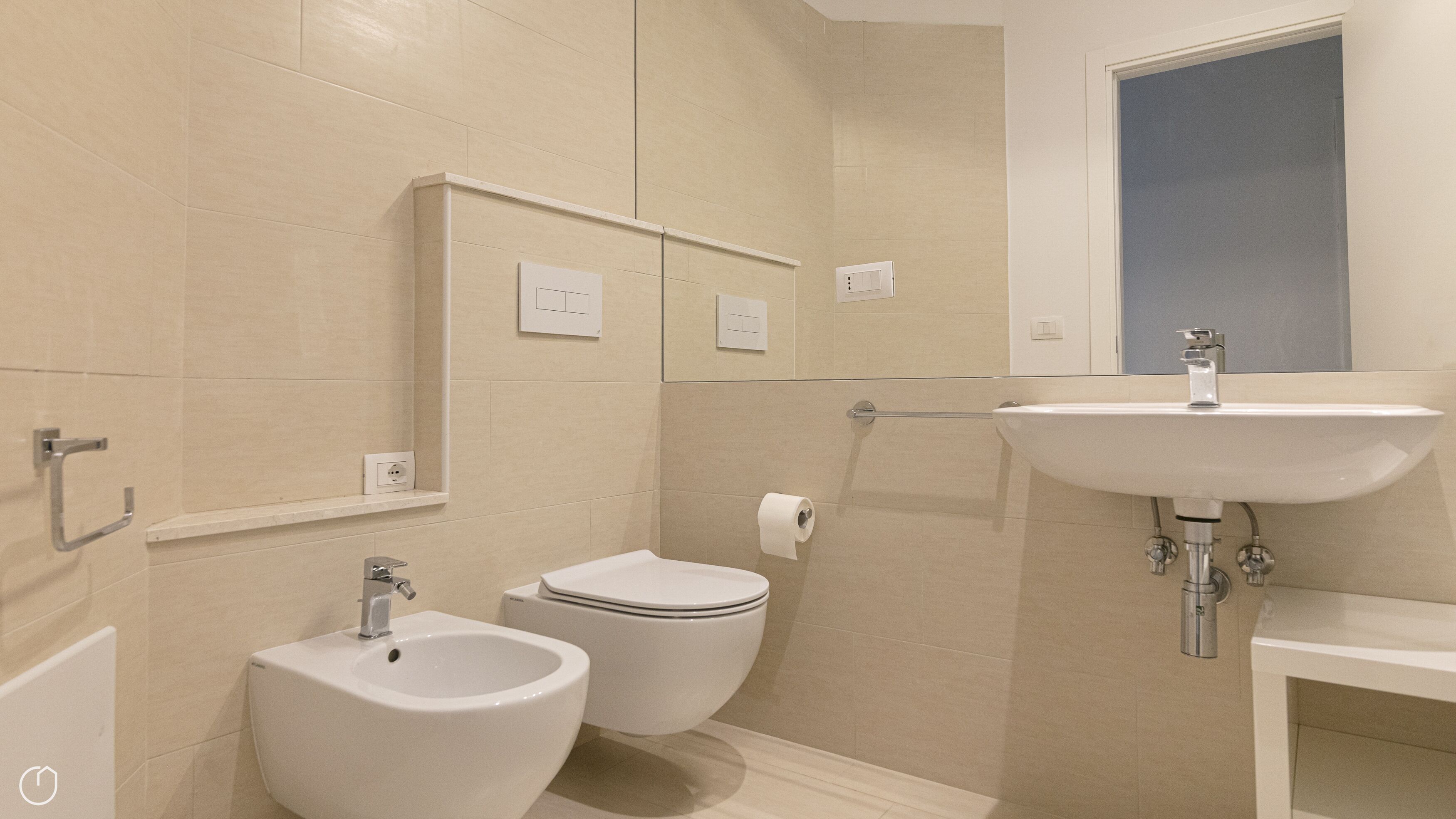 Un bany amb bidet, vàter, rentapel i mirall.