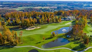 A golf course with multiple bunkers, water hazards, and a clubhouse.